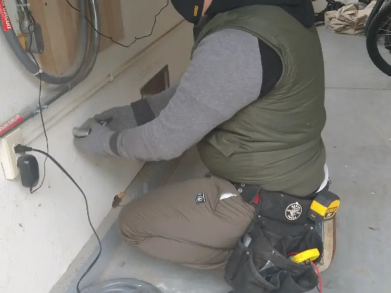 Electrician performing outlet wiring in a Zumbrota garage